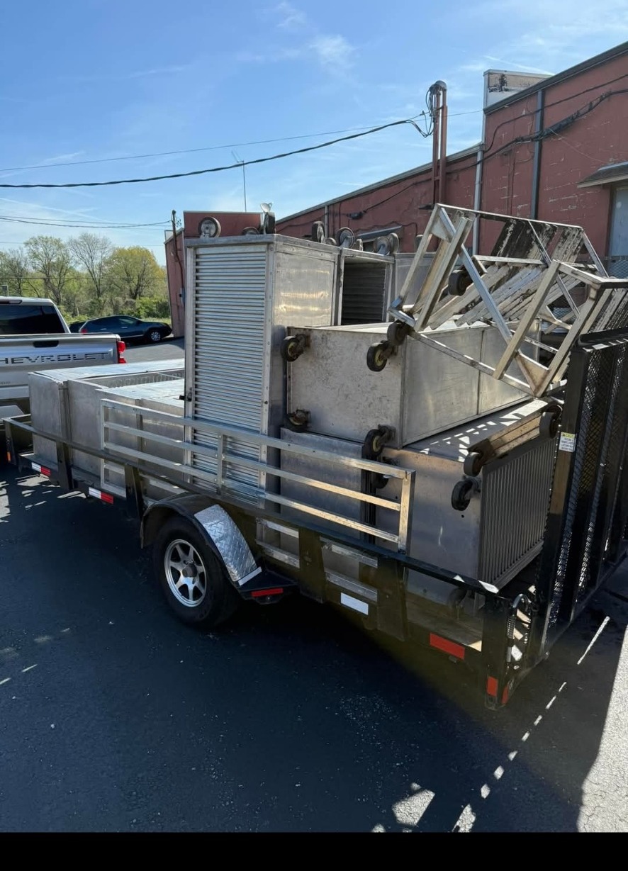 White Chevrolet truck with trailer hauling equipment